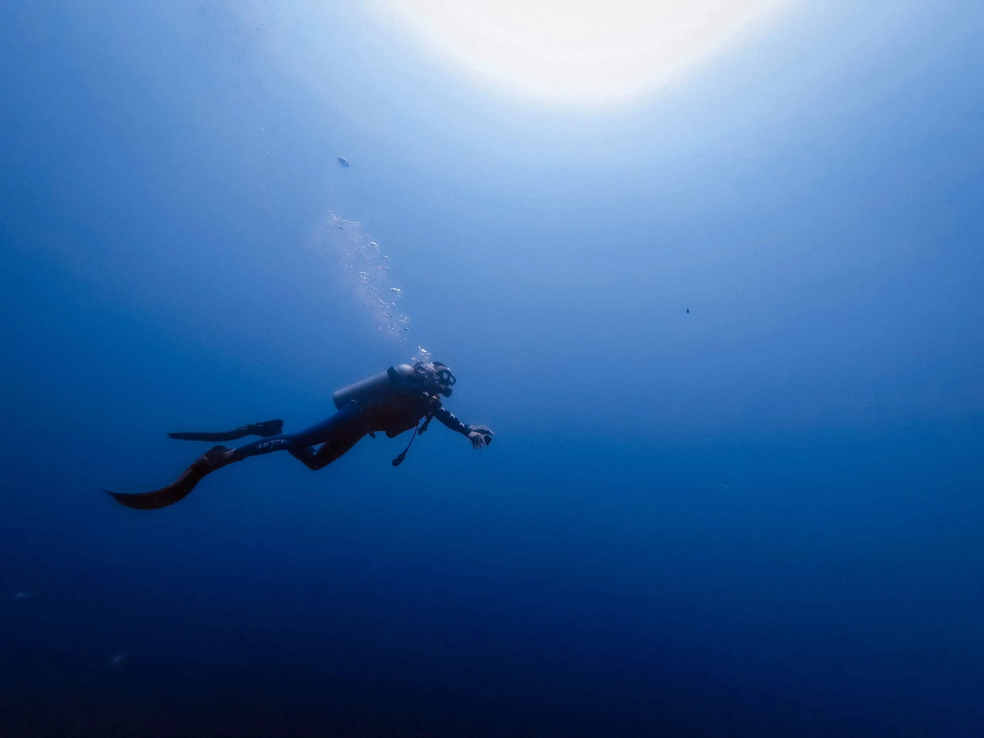 Diver suspended in deep blue water