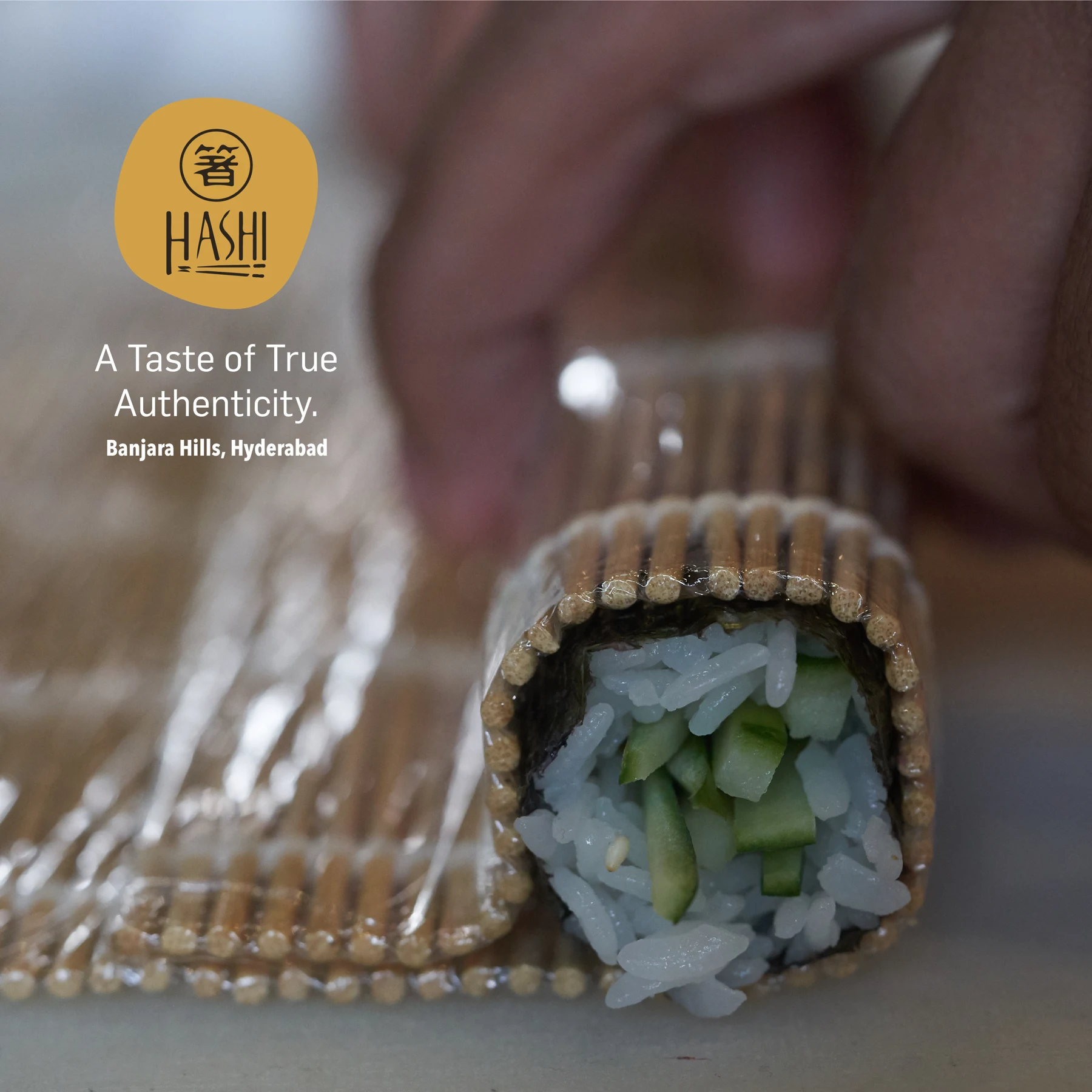 Hands rolling sushi with a bamboo mat
